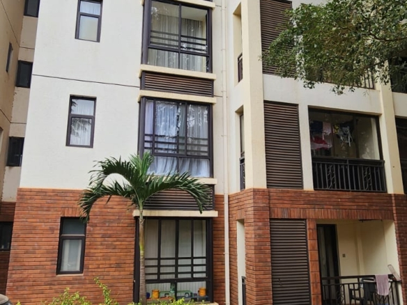 “Spacious living room at Jacaranda Gardens Apartments with natural lighting and balcony”
