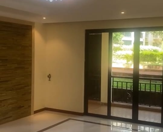 “Spacious living room at Jacaranda Gardens Apartments with natural lighting and balcony”