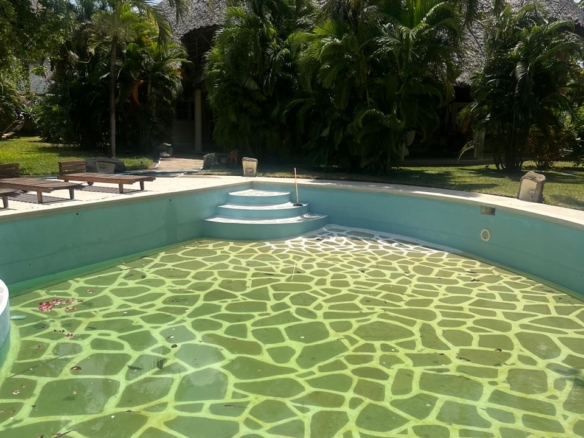 Prime 4-bedroom coastal home for sale in Kibokoni with a 2-bedroom guest suite earning USD 100 per night. Nearly half-acre plot, ideal for investors and families.