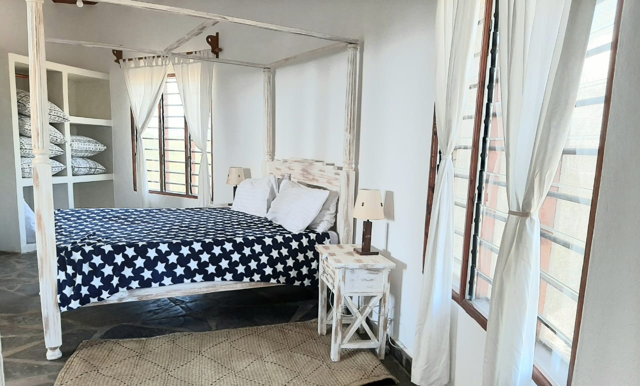 Luxury 2-bedroom guest suite in Mayungu, Malindi featuring ocean views, ensuite rooms, shared kitchen, furnished patio, tropical gardens, and a pristine swimming pool. Perfect self-catering coastal accommodation for only USD 100 per night.