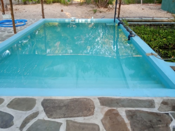 3-bedroom coastal home on 1-acre titled plot in Che Shale with solar panels, rainwater harvesting, balcony, and verandah. Expansion potential on adjoining 3/4-acre land.