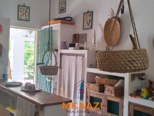 3-bedroom coastal home on 1-acre titled plot in Che Shale with solar panels, rainwater harvesting, balcony, and verandah. Expansion potential on adjoining 3/4-acre land.