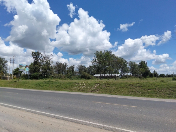 Prime 1/2-acre road frontage land for sale in Kitengela Kimalat touching main tarmac road ideal for commercial, institutional, hospitality, and residential development.
