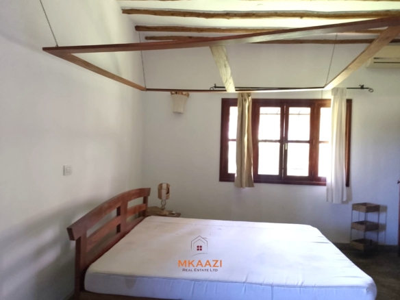 Luxury 4-bedroom en-suite villa for sale near Marine Park Road Malindi with shared pool, private garden, and makuti roof.