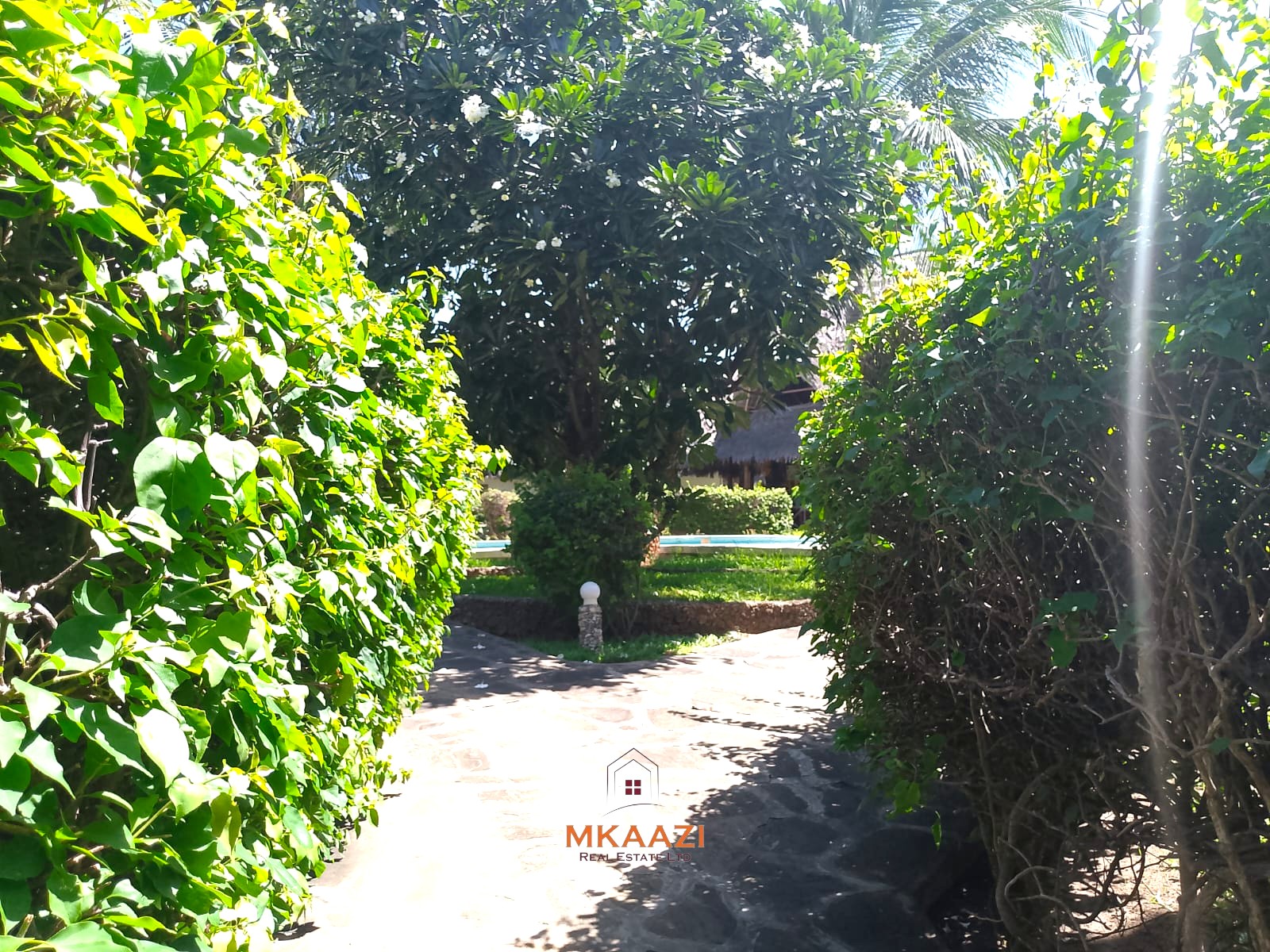 Luxury 4-bedroom en-suite villa for sale near Marine Park Road Malindi with shared pool, private garden, and makuti roof.