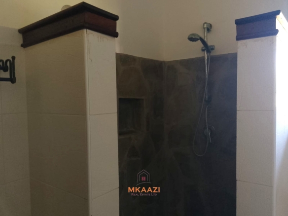 Luxury 4-bedroom en-suite villa for sale near Marine Park Road Malindi with shared pool, private garden, and makuti roof.