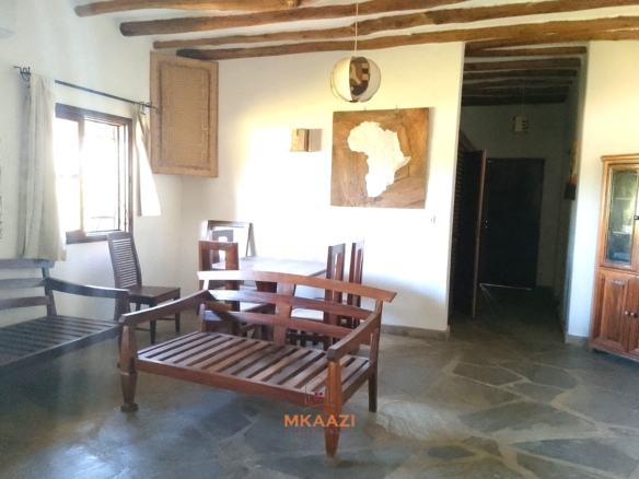 Luxury 4-bedroom en-suite villa for sale near Marine Park Road Malindi with shared pool, private garden, and makuti roof.
