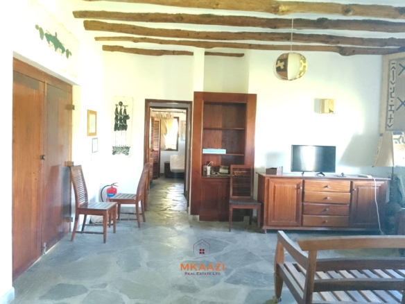 Luxury 4-bedroom en-suite villa for sale near Marine Park Road Malindi with shared pool, private garden, and makuti roof.