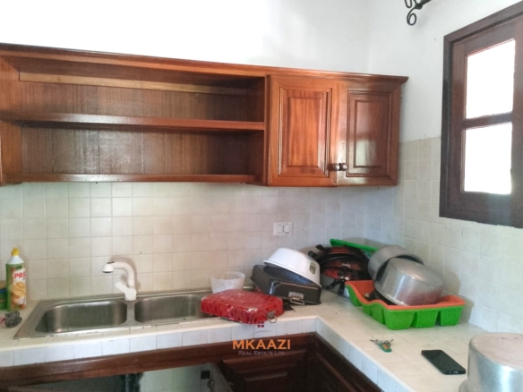 Luxury 4-bedroom en-suite villa for sale near Marine Park Road Malindi with shared pool, private garden, and makuti roof.
