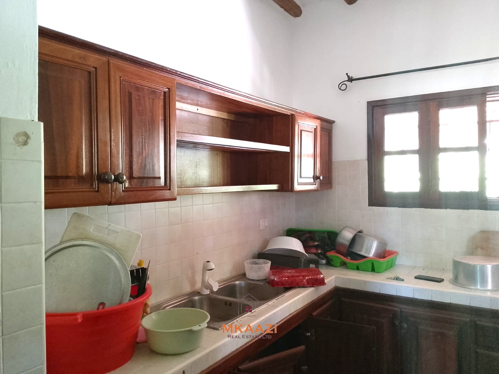 Luxury 4-bedroom en-suite villa for sale near Marine Park Road Malindi with shared pool, private garden, and makuti roof.