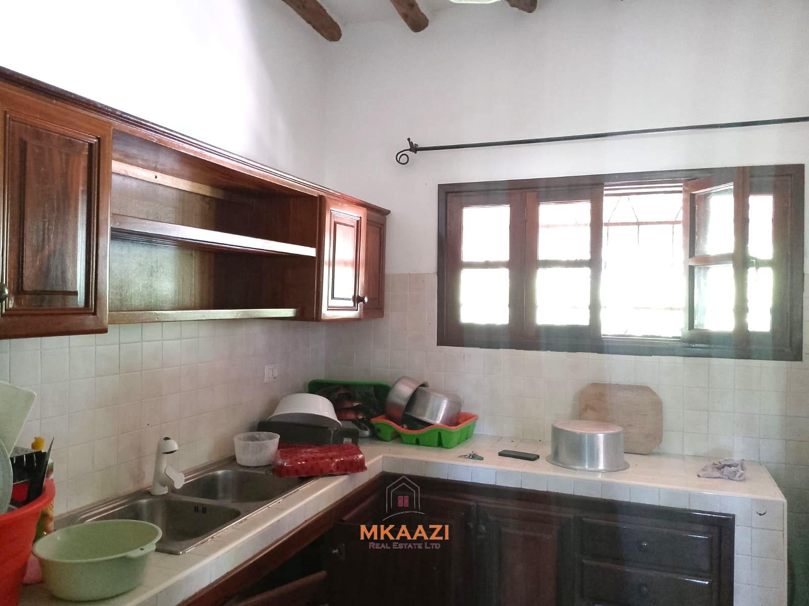 Luxury 4-bedroom en-suite villa for sale near Marine Park Road Malindi with shared pool, private garden, and makuti roof.