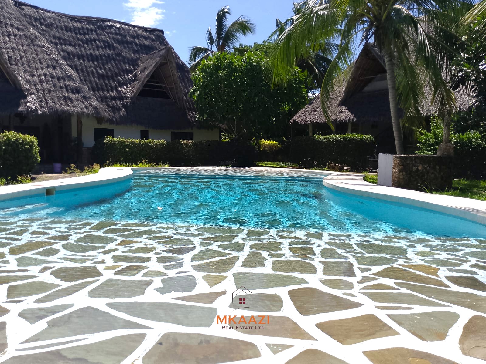 Luxury 4-bedroom en-suite villa for sale near Marine Park Road Malindi with shared pool, private garden, and makuti roof.