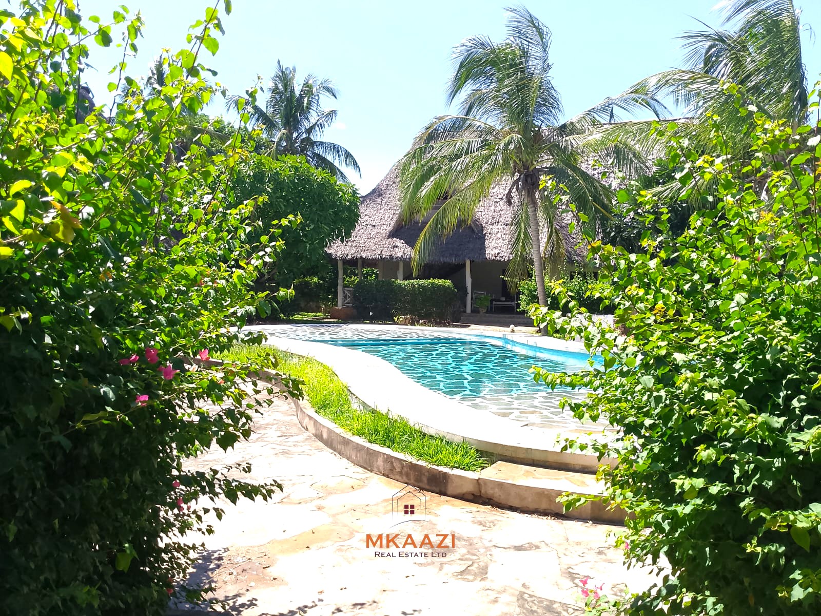 Luxury 4-bedroom en-suite villa for sale near Marine Park Road Malindi with shared pool, private garden, and makuti roof.