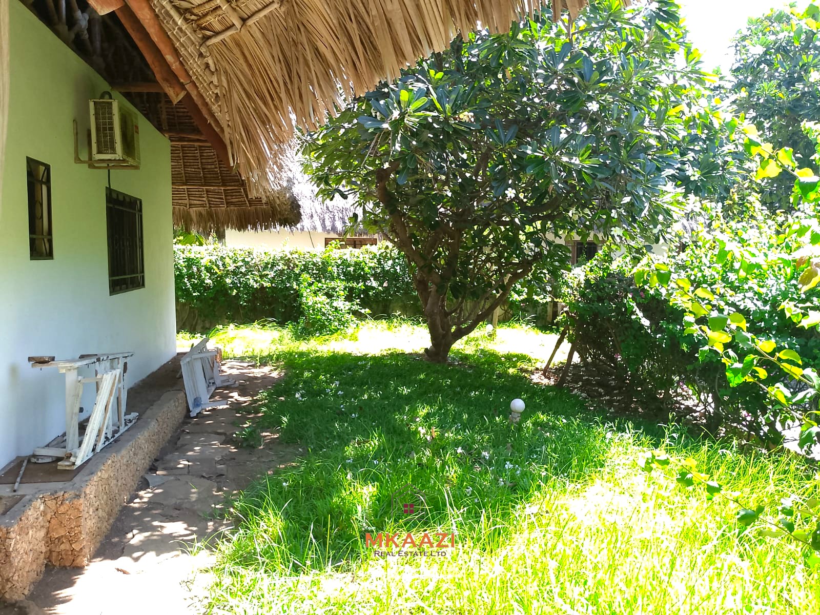 Luxury 4-bedroom en-suite villa for sale near Marine Park Road Malindi with shared pool, private garden, and makuti roof.
