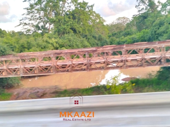 37 acres freehold cliffside road frontage land for sale at Marafa Bridge overlooking seasonal river and Marafa town ideal for agriculture, hospitality, and investment development.