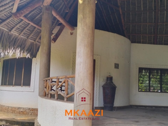 Luxury 4-bedroom house for sale in Mayungu, located in a secure gated community on the second row from the beach, featuring a shared swimming pool, landscaped garden, and serene coastal surroundings.