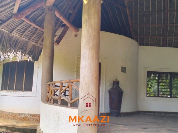 Luxury 4-bedroom house for sale in Mayungu, located in a secure gated community on the second row from the beach, featuring a shared swimming pool, landscaped garden, and serene coastal surroundings.