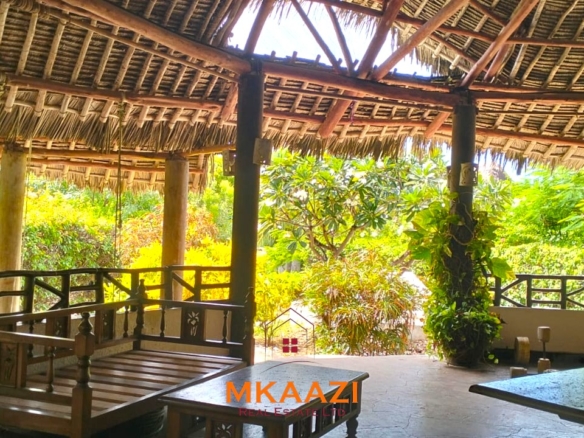 Luxury 4-bedroom house for sale in Mayungu, located in a secure gated community on the second row from the beach, featuring a shared swimming pool, landscaped garden, and serene coastal surroundings.