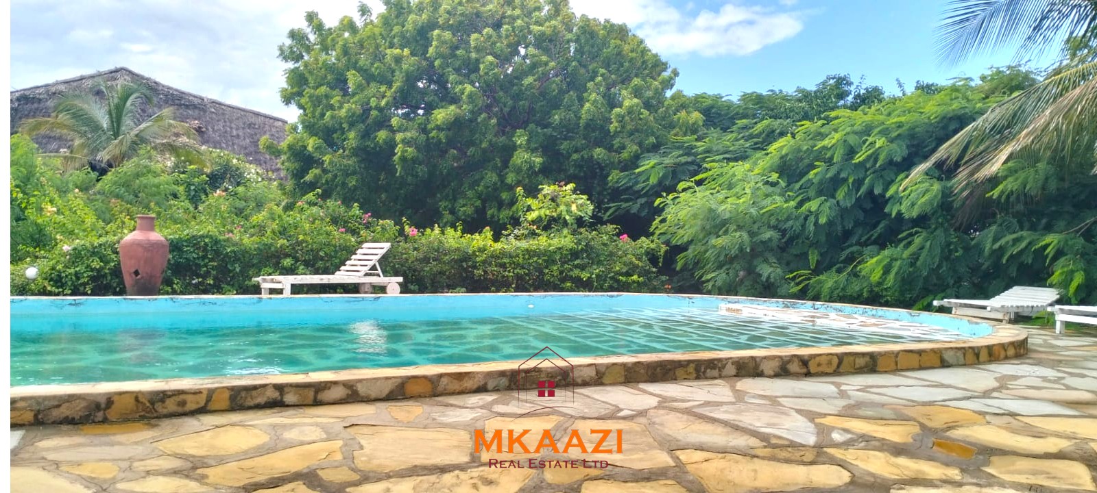 Luxury 4-bedroom house for sale in Mayungu, located in a secure gated community on the second row from the beach, featuring a shared swimming pool, landscaped garden, and serene coastal surroundings.