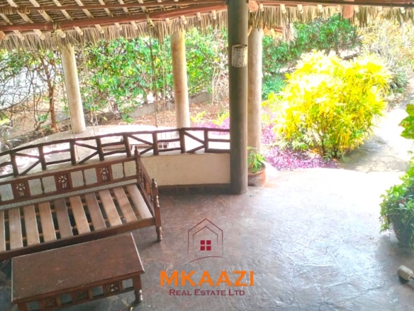 Luxury 4-bedroom house for sale in Mayungu, located in a secure gated community on the second row from the beach, featuring a shared swimming pool, landscaped garden, and serene coastal surroundings.