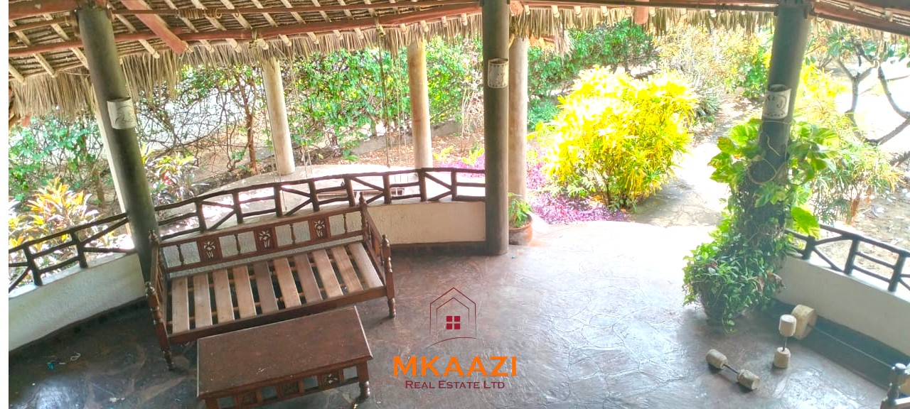 Luxury 4-bedroom house for sale in Mayungu, located in a secure gated community on the second row from the beach, featuring a shared swimming pool, landscaped garden, and serene coastal surroundings.