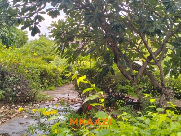 Luxury 4-bedroom house for sale in Mayungu, located in a secure gated community on the second row from the beach, featuring a shared swimming pool, landscaped garden, and serene coastal surroundings.