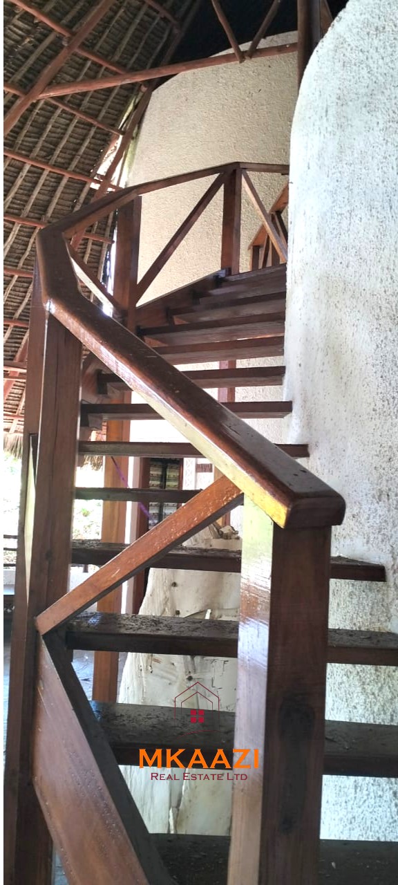 Luxury 4-bedroom house for sale in Mayungu, located in a secure gated community on the second row from the beach, featuring a shared swimming pool, landscaped garden, and serene coastal surroundings.