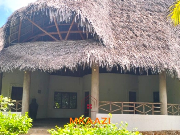 Luxury 4-bedroom house for sale in Mayungu, located in a secure gated community on the second row from the beach, featuring a shared swimming pool, landscaped garden, and serene coastal surroundings.