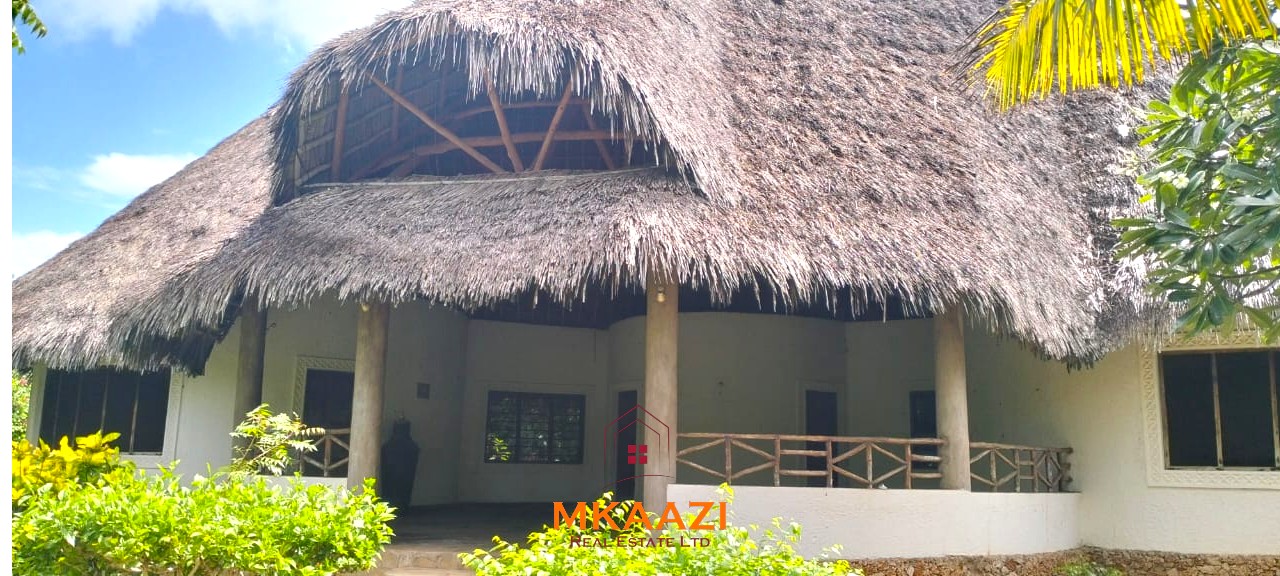 Luxury 4-bedroom house for sale in Mayungu, located in a secure gated community on the second row from the beach, featuring a shared swimming pool, landscaped garden, and serene coastal surroundings.