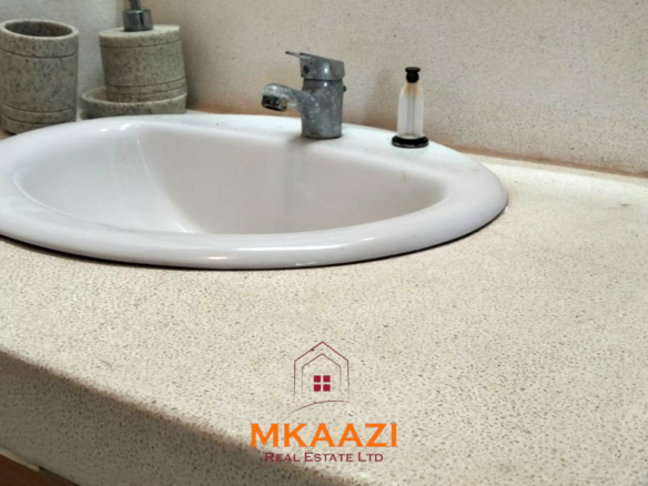 Luxury 4-bedroom house for sale in Mayungu, located in a secure gated community on the second row from the beach, featuring a shared swimming pool, landscaped garden, and serene coastal surroundings.