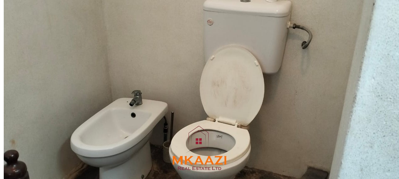 Luxury 4-bedroom house for sale in Mayungu, located in a secure gated community on the second row from the beach, featuring a shared swimming pool, landscaped garden, and serene coastal surroundings.