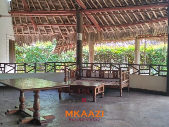 Luxury 4-bedroom house for sale in Mayungu, located in a secure gated community on the second row from the beach, featuring a shared swimming pool, landscaped garden, and serene coastal surroundings.