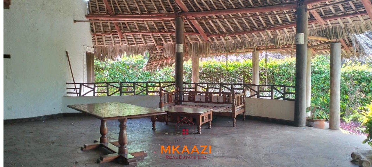 Luxury 4-bedroom house for sale in Mayungu, located in a secure gated community on the second row from the beach, featuring a shared swimming pool, landscaped garden, and serene coastal surroundings.