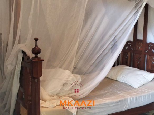 Luxury 4-bedroom house for sale in Mayungu, located in a secure gated community on the second row from the beach, featuring a shared swimming pool, landscaped garden, and serene coastal surroundings.