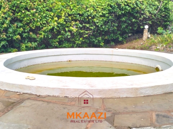 Luxury 4-bedroom house for sale in Mayungu, located in a secure gated community on the second row from the beach, featuring a shared swimming pool, landscaped garden, and serene coastal surroundings.