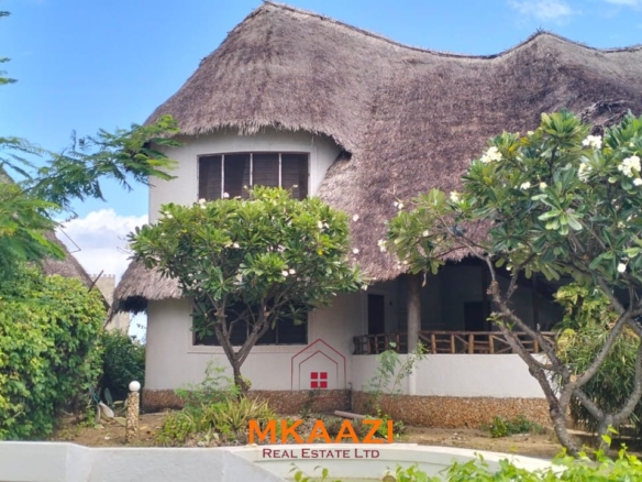 Luxury 4-bedroom house for sale in Mayungu, located in a secure gated community on the second row from the beach, featuring a shared swimming pool, landscaped garden, and serene coastal surroundings.