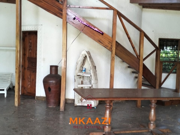 Luxury 4-bedroom house for sale in Mayungu, located in a secure gated community on the second row from the beach, featuring a shared swimming pool, landscaped garden, and serene coastal surroundings.