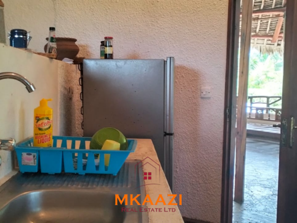 Luxury 4-bedroom house for sale in Mayungu, located in a secure gated community on the second row from the beach, featuring a shared swimming pool, landscaped garden, and serene coastal surroundings.