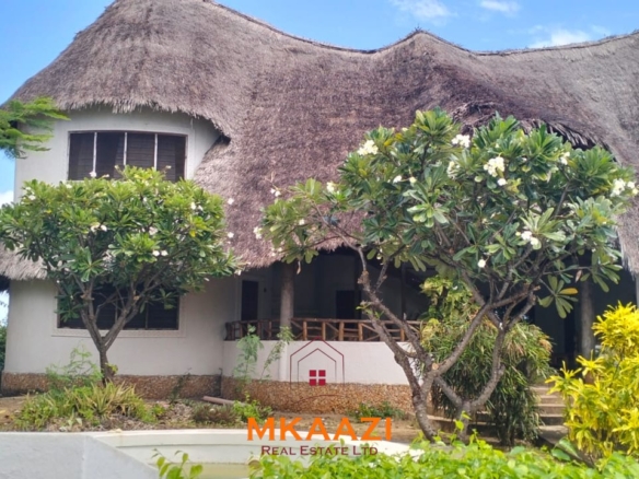 Luxury 4-bedroom house for sale in Mayungu, located in a secure gated community on the second row from the beach, featuring a shared swimming pool, landscaped garden, and serene coastal surroundings.
