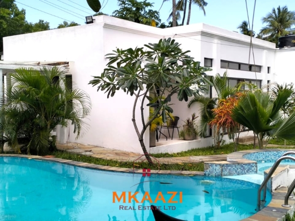 Two 2-bedroom bungalows for sale near Garoda on a quarter-acre property featuring ensuite master bedrooms with bathtubs, swimming pool, landscaped gardens, and operating as a hospitality business.