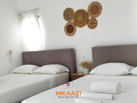 Two 2-bedroom bungalows for sale near Garoda on a quarter-acre property featuring ensuite master bedrooms with bathtubs, swimming pool, landscaped gardens, and operating as a hospitality business.