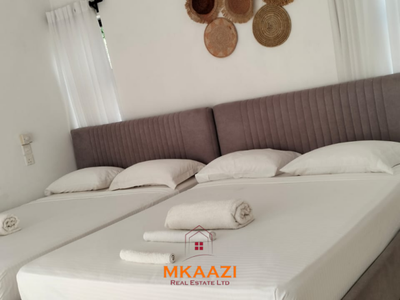 Two 2-bedroom bungalows for sale near Garoda on a quarter-acre property featuring ensuite master bedrooms with bathtubs, swimming pool, landscaped gardens, and operating as a hospitality business.