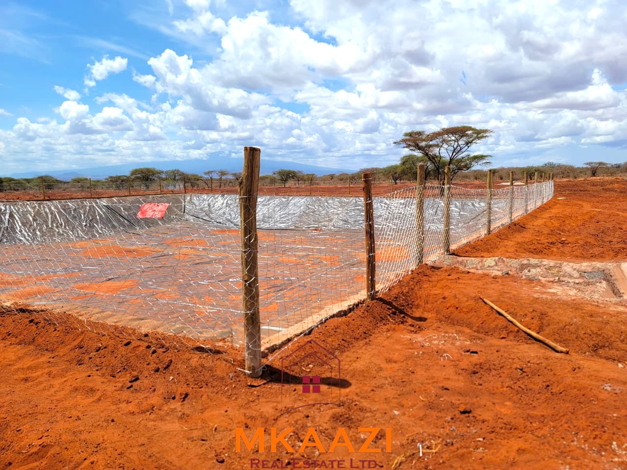 17-acre income-generating farm for sale in Mata, Taveta featuring mature Muguka cultivation, a 6-million-litre dam, borehole, irrigation system, indigenous trees, and electric fencing.