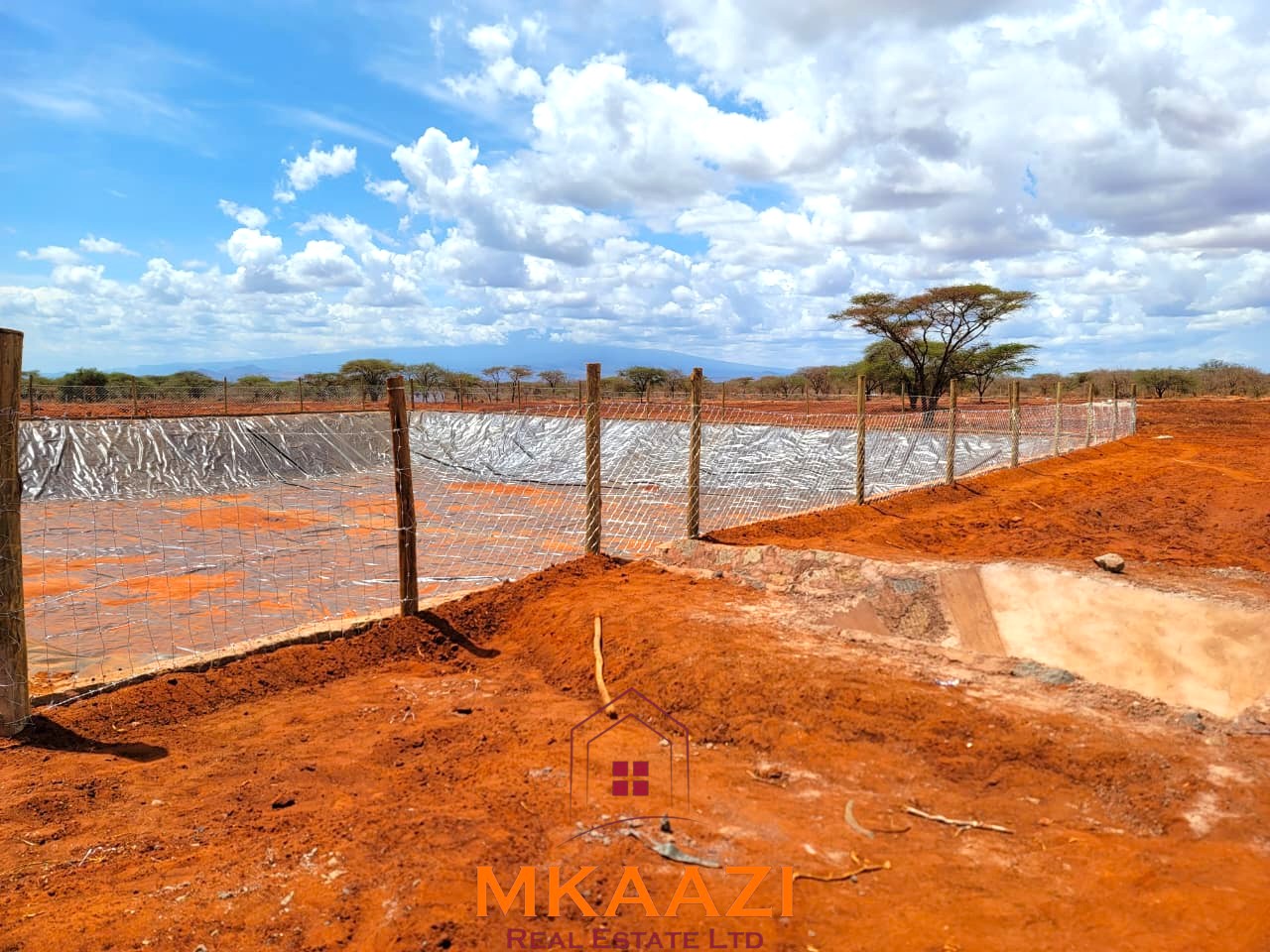 17-acre income-generating farm for sale in Mata, Taveta featuring mature Muguka cultivation, a 6-million-litre dam, borehole, irrigation system, indigenous trees, and electric fencing.
