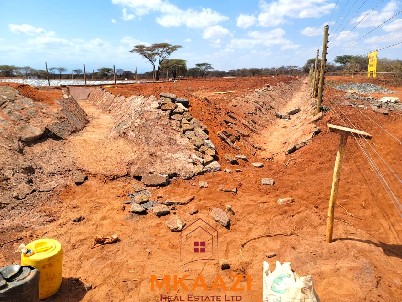17-acre income-generating farm for sale in Mata, Taveta featuring mature Muguka cultivation, a 6-million-litre dam, borehole, irrigation system, indigenous trees, and electric fencing.