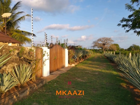 Luxury 3-bedroom all en-suite villa on 1.5 acres in Kikambala featuring a guest house, swimming pool, landscaped gardens, ocean breeze, and easy beach access.