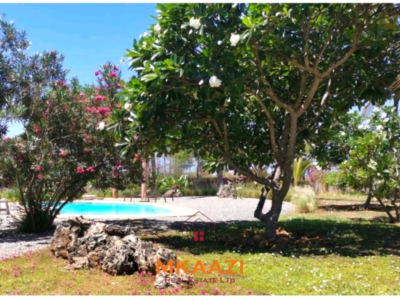 Luxury 3-bedroom all en-suite villa on 1.5 acres in Kikambala featuring a guest house, swimming pool, landscaped gardens, ocean breeze, and easy beach access.