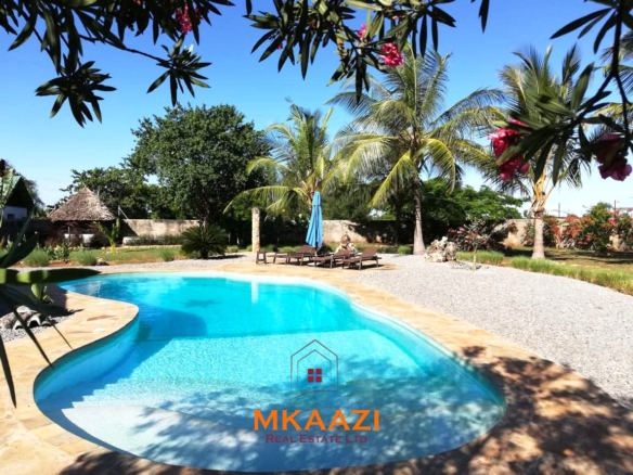 Luxury 3-bedroom all en-suite villa on 1.5 acres in Kikambala featuring a guest house, swimming pool, landscaped gardens, ocean breeze, and easy beach access.