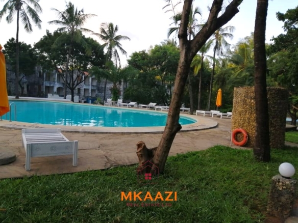 Fully furnished 85 sqm one-bedroom apartment for sale at Blue Marlin Sporting Resort Malindi with pool, gym, security, reception, and beach access.