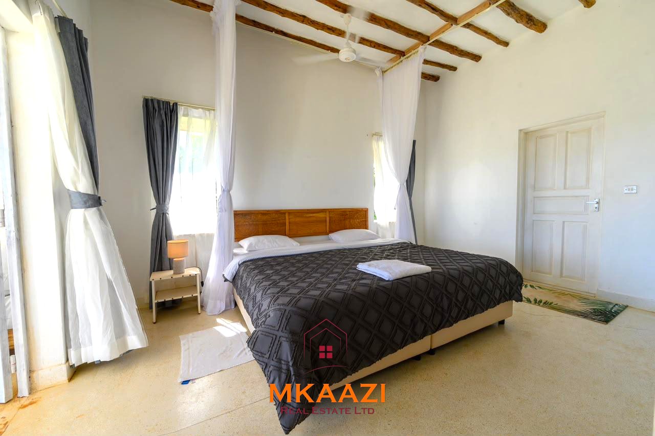Fully furnished 4-bedroom riverside holiday house accommodating up to 10 guests with hippo views, spacious compound, and fully equipped kitchen.